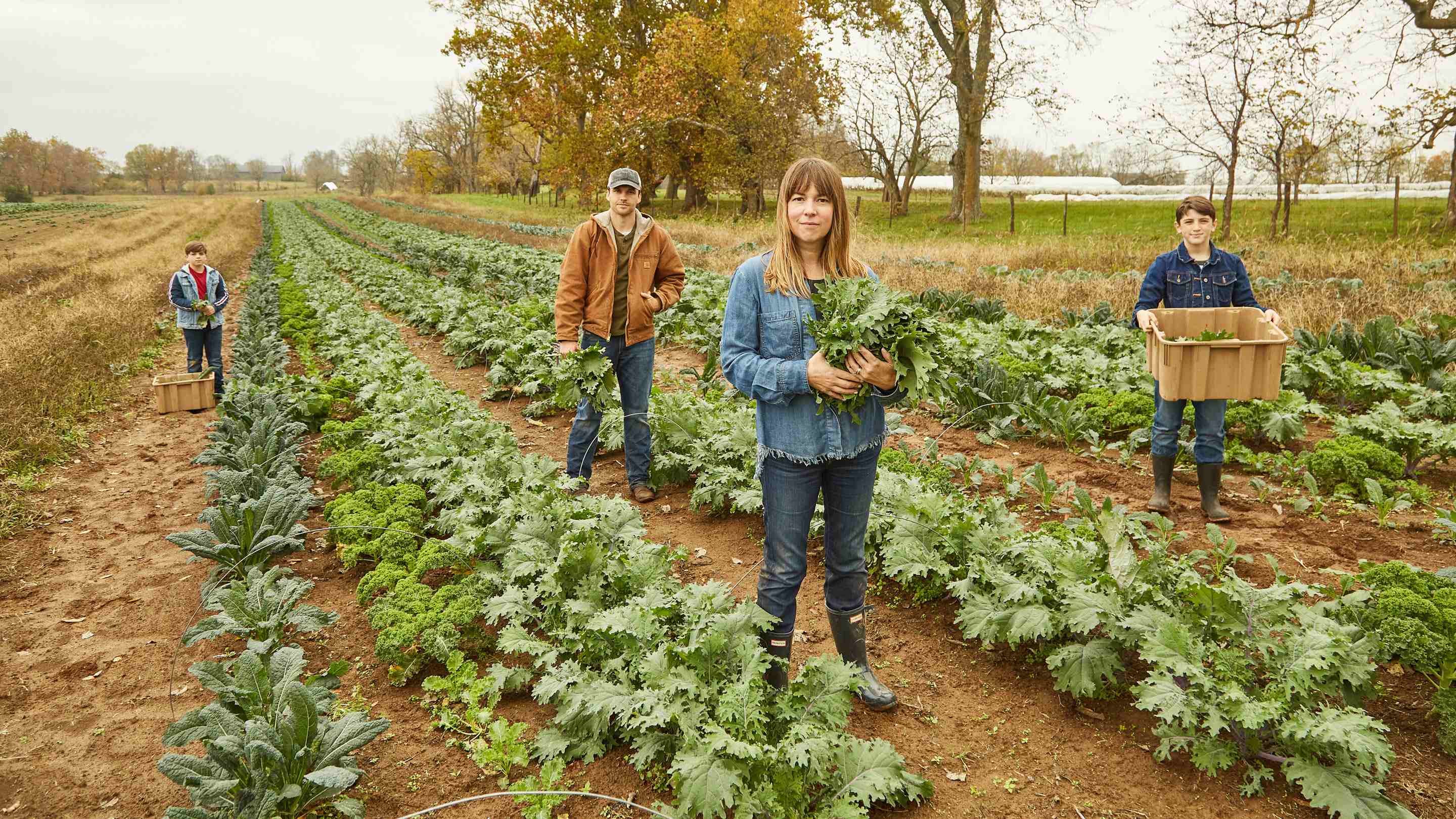 family of farmers standing in a field